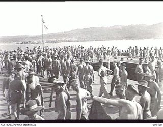 WEWAK HARBOUR, NEW GUINEA, 1945-12-13. APPROXIMATELY 2,200 MEMBERS OF 6 DIVISION EMBARKED ON THE AIRCRAFT CARRIER HMS IMPLACABLE FOR RETURN TO AUSTRALIA. SHOWN, THE TROOPS LINED UP ON THE FLIGHT ..