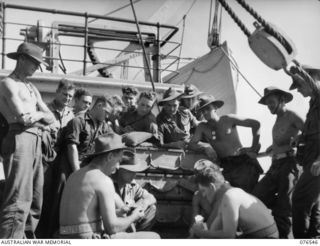 AT SEA, NEW GUINEA. 1944-10-07. TROOPS OF THE 36TH INFANTRY BATTALION ENJOYING A GAME OF POKER ABOARD THE DUTCH TROOPSHIP, "SWARTENHONDT" WHILE EN ROUTE TO NEW BRITAIN. IDENTIFIED PERSONNEL ARE:- ..