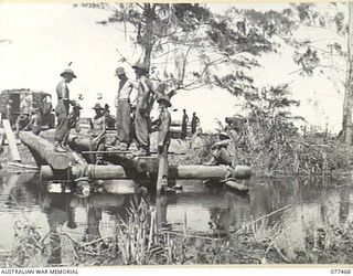 BABIANG ROAD, AITAPE AREA, NEW GUINEA. 1944-12-04. PERSONNEL OF NO. 7 PLATOON, 2/8TH FIELD COMPANY, WORKING ON THE CONSTRUCTION OF A 60-FOOT BRIDGE ACROSS A STREAM NEAR DRINIUMOR ON THE ..