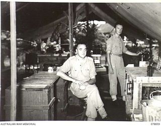 TOROKINA, BOUGAINVILLE ISLAND. 1945-02-04. TX2033 MAJOR R.O. LYONS, DENTAL OFFICER (1) AND NX173933 CORPORAL D.S. FAHL, DENTAL ORDERLY (2) IN THE WORKSHOP OF THE 63RD DENTAL UNIT