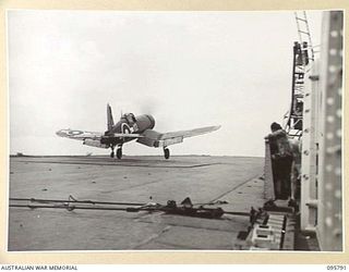 AT SEA OFF RABAUL, NEW BRITAIN. 1945-09-06. A CORSAIR AIRCRAFT TAKING OFF TO JOIN IN WITH OTHER PLANES CIRCLING OVERHEAD WHILE MEMBERS OF THE JAPANESE SURRENDER PARTY WERE BOARDING THE AIRCRAFT ..