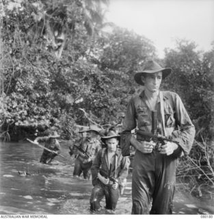 SIAR, NEW GUINEA. 1944-07-04. AUSTRALIAN TROOPS OF THE 57/60TH INFANTRY BATTALION, 15TH INFANTRY BRIGADE MOVE TO HIGHER GROUND FROM A JUNGLE STREAM. IDENTIFIED PERSONNEL ARE:- V320874 PRIVATE J.J. ..