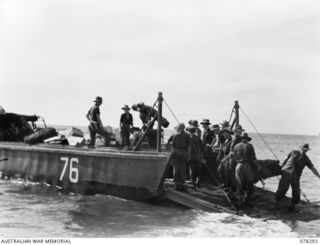 SIPAAI, BOUGAINVILLE ISLAND. 1945-01-07. TROOPS OF THE 31/51ST INFANTRY BATTALION UNLOADING THE UNIT STORES FROM BARGES OF THE 42ND LANDING CRAFT COMPANY AT THE UNIT BEACH-HEAD AT THE MOUTH OF THE ..