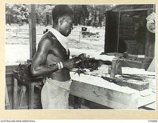 LAE AREA, NEW GUINEA. 1944-11-15. A NEW GUINEA NATIVE OPERATING A WOOD TURNING LATHE IN THE GENERAL ENGINEERING SECTION OF THE 2/7TH ADVANCED WORKSHOPS