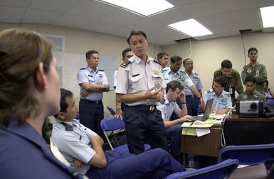 Major Francis Ngooi Choong Ngee, Air Operations Department, Singapore confirms air drop data presented by FLGOFF (Flying Officer) Melissa Dalby, 86 Wing (WG), Royal Australian Air Force, during PACIFIC AIRLIFT RALLY 2001. PACIFIC AIRLIFT RALLY (PAR) is a PACAF-sponsored military airlift symposium for countries in the pacific region. PAR is held every two years and is hosted by a pacific nation. This year Andersen AFB, Guam is the host nation. The symposium includes informational seminars with area of expertise briefings, a command post exercise (CPX) which addresses military airlift support to a humanitarian airlift/disaster relief scenario, and a concurrent flying training program...