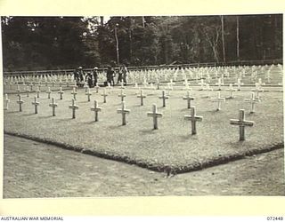 SOPUTA, NEW GUINEA. 1944-04-17. NATIVE LABOURERS WORKING BESIDE AUSTRALIAN GRAVES AT THE SOPUTA WAR CEMETERY. (JOINS NO.72449)