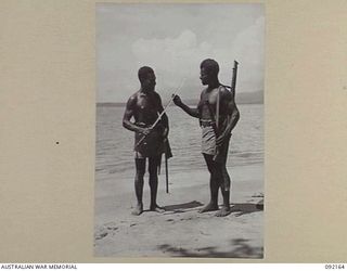 WEWAK AREA, NEW GUINEA. 1945-05-13. CONSTABLE BIR (1), AND CONSTABLE BAKET (2), HEADQUARTERS AUSTRALIAN NEW GUINEA ADMINISTRATIVE UNIT POLICE BOYS SHOWN WITH A JAPANESE SWORD WHICH THEY CAPTURED ..