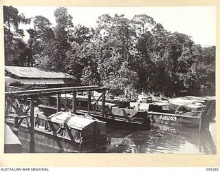 KALUMALAGI RIVER, JACQUINOT BAY, NEW BRITAIN, 1945-08-12. A GENERAL VIEW OF BARGES, SLIPWAY AND WORKSHOPS ON THE BANK OF THE RIVER AT 1 INFANTRY TROOPS WORKSHOP