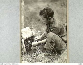 YAULA, NEW GUINEA. 1944-04-09. V300327 SIGNALMAN R.J. LEWIS, 57/60TH INFANTRY BATTALION IN CONTACT WITH A PATROL USING A MARK III 108 WIRELESS SET, THIS SET IS POPULARLY KNOWN AS "MICKIE"