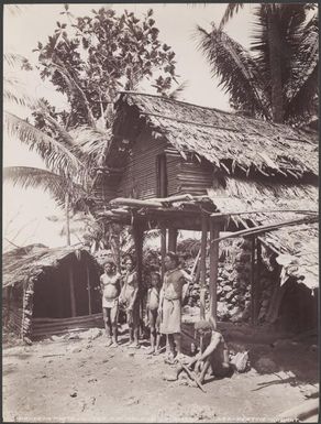 Men standing under a stilt house in the village of Foate, Malaita, Solomon Islands, 1906 / J.W. Beattie