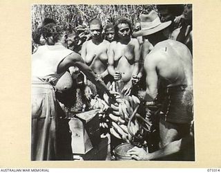 YULE ISLAND, NEW GUINEA. 1944-05-17/18. PRIVATE MORTON, 1ST MARINE FOOD SUPPLY PLATOON (1), WITH AN INTERPRETER PURCHASING BUNCHES OF BANANAS FROM THE NATIVES. THE CURRENT TRADING RATE IS A TIN OF ..