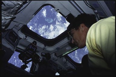 S43-02-027 - STS-043 - STS-43 Blaha looks through a window on OV-104's aft flight deck