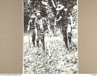 1943-08-14. NEW GUINEA. MOUNT TAMBU FIGHTING. ALLIED SOLDIERS WALKING THROUGH MUD AND SLUSH WHICH CONTINUES FOR MILES. (NEGATIVE BY G. SHORT)