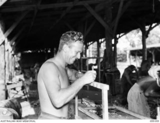 TOROKINA, BOUGAINVILLE, 1945-12-03. SIGNALMAN W. PERRY MAKING A DECK CHAIR IN THE CARPENTRY SECTION, TOROKINA REHABILITATION TRAINING CENTRE