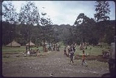 Western Highlands: people beside a road at hotel lodging built in style of traditional houses