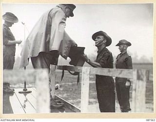 HERBERTON, QUEENSLAND. 1945-03-03. MAJOR GENERAL G.F. WOOTTEN, GENERAL OFFICER COMMANDING 9 DIVISION, (1), PRESENTING TROPHIES TO HEADQUARTERS 24 INFANTRY BRIGADE TROOPS DURING A PARADE AT THE ..