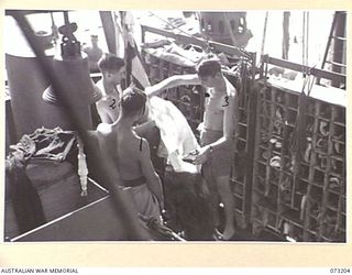 OFF MADANG, NEW GUINEA. 1944-05-14. SIGNALMEN ABOARD THE RAN FRIGATE HMAS BARCOO PREPARE TO HOIST FLAGS TO SIGNAL PORT ON THEIR RETURN TO MADANG FROM AN ACTIVE PATROL. IDENTIFIED ARE: B3618 ..