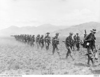 THE 2/27TH AUSTRALIAN INFANTRY BATTALION, MOVING FORWARD ACROSS THE VALLEY. BELIEVED TO BE B COMPANY 10 PLATOON