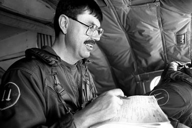 A crew member of a Naval Air Reserve Patrol Squadron 64 (VP-64) P-3 Orion aircraft on active duty training consults a data sheet