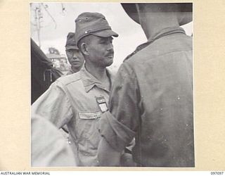 MOUNT SHIBURANGU, WEWAK AREA, NEW GUINEA. 1945-09-21. MAJOR GENERAL ARAKI OF 18 JAPANESE ARMY, BEING SEARCHED FOR WEAPONS AT A CONTROLLING POINT AT MAKOW ON THE TOP OF MOUNT SHIBURANGU, WHICH WAS ..