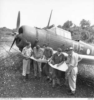 FINSCHHAFEN, NEW GUINEA. 1943-10-30. RAAF OFFICERS AND THE G111 AIR, 9TH AUSTRALIAN DIVISION, DISCUSSING TACTICS WITH THE AID OF MAPS WHILE STANDING BESIDE A WIRRAWAY AIRCRAFT. LEFT TO RIGHT: 20326 ..