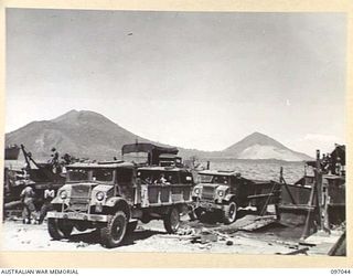 RABAUL, NEW BRITAIN. 1945-09-20. UNLOADING TRUCKS AT THE NEWLY ESTABLISHED BEACH-HEAD ON 28 INFANTRY BATTALION AREA. THESE VEHICLES WERE BROUGHT BY THE ANDREW BRISCOE, THE FIRST VICTORY SHIP TO ..