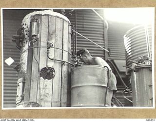 17 MILE, LALOKI RIVER, NEW GUINEA. 1943-11-22. W62911 PRIVATE L. M. HARDY OF THE AUSTRALIAN DEFENCE CANTEEN SERVICE ATTACHED TO HEADQUARTERS, NEW GUINEA FORCE, ATTENDING TO THE WATER FILTERING AND ..