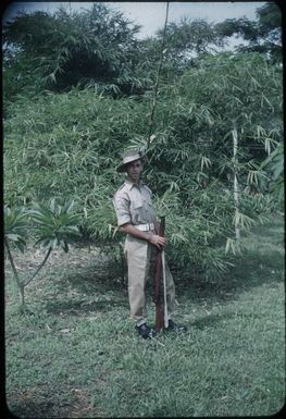Kit Denton, in uniform, is holding a gun : Port Moresby, Papua New Guinea, 1953 / Terence and Margaret Spencer