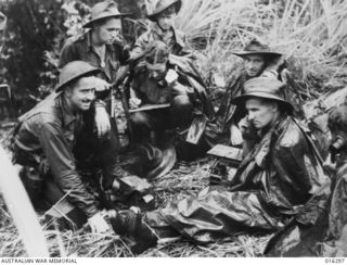 HEAVY RAIN MADE WORK MORE DIFFICULT TO KEEP MAPS AND WRITING MATERIAL DRY AT A FORWARD COMMAND POST DURING THE BATTLE IN WHICH INFANTRY UNITS OF 29TH/46TH BATTALION INFLICTED SEVERE CASUALTIES ON ..