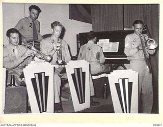 LAE AREA, NEW GUINEA, 1945-07-09. THE REGIMENTAL HEADQUARTERS 2/1 GUARD REGIMENT DANCE BAND PERFORMING DURING THE REVUE "OVER TO YOU" STAGED BY 19 LINES OF COMMUNICATION AREA SIGNALS. IT WAS HELD ..