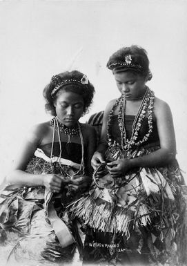 Unidentified Samoan women in traditional clothing, making wreaths