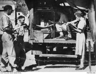 Port Moresby, New Guinea. c. 1944. A member of the Australian Army Medical Women's Service (AAMWS) stands at the rear of an ambulance checking personnel as they are unloaded at an Australian ..