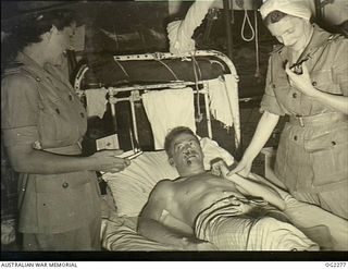 TOROKINA, BOUGAINVILLE ISLAND, SOLOMON ISLANDS. C. 1945-02-23. SENIOR RED CROSS REPRESENTATIVE SHEILA GRAHAM OF SYDNEY, NSW (LEFT), WHOSE DUTIES INCLUDE VISITS TO RAAF HOSPITAL TO SUPPLY COMFORTS ..