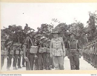 JACQUINOT AIRSTRIP, NEW BRITAIN. 1945-03-29. LORD WAKEHURST, GOVERNOR OF NEW SOUTH WALES (3), WITH MAJOR A.O. BALDWIN, GUARD COMMANDER (4), INSPECTING A GUARD OF HONOUR AT HEADQUARTERS 4 INFANTRY ..