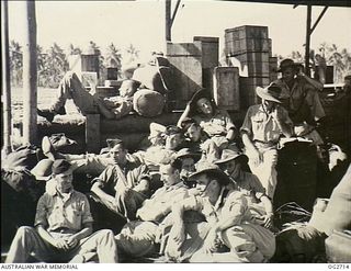 NEW GUINEA. C. 1944. INFORMAL GROUP PORTRAIT OF MEMBERS OF THE RAAF HOMEWARD BOUND, AFTER HAVING COMPLETED TWELVE TO FIFTEEN MONTHS SERVICE. THEY ARE WAITING FOR A DOUGLAS TRANSPORT AIRCRAFT THAT ..