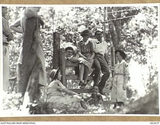 KOITAKI, NEW GUNINEA. 1944-01-02. PATIENTS AND MEMBERS OF THE STAFF OF THE 47TH AUSTRALIAN CAMP HOSPITAL RESTING AFTER A STROLL THROUGH THE LOCAL RUBBER PLANTATION. IDENTIFIED PERSONNEL ARE: ..