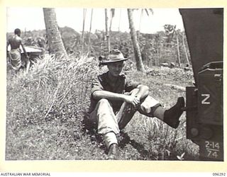 MALAGUNA MISSION, NEW BRITAIN. 1945-09-10. LEADING BOMBARDIER J. NEILSON, 2/14 FIELD REGIMENT, ENJOYS A SMOKE ON THE BEACH DURING THE FIRST DAY OF OCCUPATION OF THE RABAUL AREA BY 4 INFANTRY ..