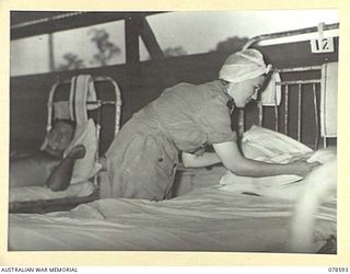 BOUGAINVILLE ISLAND. 1945-01-23. NFX138810 SISTER E.A. LALOR MAKING UP A BED IN THE TENT WARD OF THE 2/1ST AUSTRALIAN GENERAL HOSPITAL