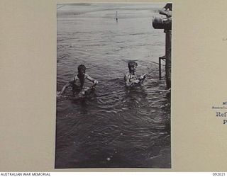 URFIP CREEK, WEWAK AREA, 1945-05-14. SAPPERS OF 9 PLATOON, 2/8 FIELD COMPANY, ROYAL AUSTRALIAN ENGINEERS, WADING THROUGH CREEK WATERS CARRYING AN AIR DRILL FOR DRILLING STAYS FOR THE CONSTRUCTION ..