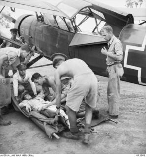 An ambulance plane brings back wounded from Kokoda. The wounded man is Private. J. W. Clont of NSW. The pilot of the plane is Staff Sergeant N. D. Maxwell of Claire, Michigan