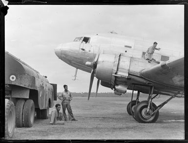 View of an RNZAF C47 transport plane and fuel tanker at [Fua'Amotu?] Airfield with unidentified personnel, Tonga