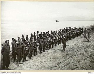 BOUGAINVILLE ISLAND. 1945-01-25. MEMBERS OF "A" COMPANY, 1ST NEW GUINEA INFANTRY BATTALION PARADING ON THE BEACH OUTSIDE THE COMPANY HEADQUARTERS SOUTH OF THE JABA RIVER. IDENTIFIED PERSONNEL ARE:- ..