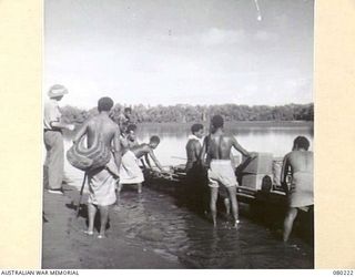 HANSA BAY, NEW GUINEA. 1944-07-08. MEMBERS OF NO.5 PLATOON, A COMPANY, 1ST PAPUAN INFANTRY BATTALION, LOAD RATIONS INTO A LAKATOI BEFORE RETURNING TO THEIR POST TO RECONNOITRE THE SEPIK AREA. NOTE ..