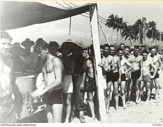 TOROKINA, BOUGAINVILLE, 1944-11-19. THE YOUNG MEN'S CHRISTIAN ASSOCIATION COFFEE STALL DOING A "ROARING" BUSINESS AT THE SURF CARNIVAL ORGANISED BY HEADQUARTERS, 3RD DIVISION