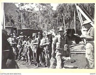 NANTAMBU, NEW BRITAIN, 1945-08-22. LIEUTENANT A.C. URQUHART, EMPLANING OFFICER, HEADQUARTERS COMPANY 37/52ND INFANTRY BATTALION CHECKS TROOPS AS THEY MOVE TO A LAUNCH, DURING TRANSPORTATION OF THE ..