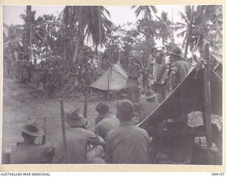 OINYALIB, NEW GUINEA. 1945-07-15. PRIVATE R. THURGOOD (1), ACCOMPANIED BY SERGEANT E. MULLER (2), SINGING THE EVER POPULAR NUMBER "JEALOUSY". THE PROGRAMME HAS BEEN PRODUCED BY MEMBERS OF NO. 5 ..