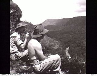 LALOKI VALLEY, NEW GUINEA. 1943-11-05. MEMBERS OF THE NEW GUINEA FORCE TRAINING SCHOOL (JUNGLE WING) PATROL LOOKING OVER THE ROUNA FALLS. SHOWN: VX50370 LIEUTENANT J. D. BRENNAN (1)