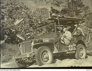 TOROKINA, BOUGAINVILLE ISLAND, SOLOMON ISLANDS. 1945-02-23. 266409 FLIGHT LIEUTENANT IAN MORRISON, GRAFTON, NSW, RAAF MEDICAL OFFICER, DRIVES HIS EMERGENCY AMBULANCE. THE AMBULANCE CONVERTED WITH ..