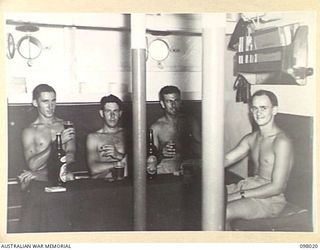 SIMPSON HARBOUR, NEW BRITAIN. 1945-10-13. OFFICERS OF THE MOTOR LAUNCH 825, ROYAL AUSTRALIAN NAVY, RELAXING IN THEIR WARD ROOM WITH SOME ICE COLD BEER. THE VESSEL IS THE ONLY MOTOR LAUNCH IN THE ..