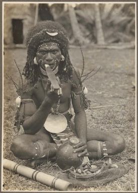 Types from Buna District [man seated, possibly eating betel nut] Frank Hurley